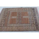 Afghan rug with a twin panel design and multiple borders on a pale terracotta ground, 5ft 8ins x 4ft