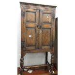 20th Century oak side cabinet, the panelled doors enclosing a later fitted interior on baluster