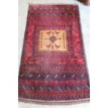 Belouch rug with a single medallion design on a banded red ground, 5ft 6ins x 3ft approximately