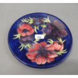 Moorcroft plate decorated with the Anemone pattern on a blue ground, 10.25ins diameter, painted