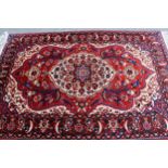 Bakhtiari rug with a medallion and all-over floral design on a red ground with ivory corner