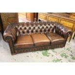 Brown buttoned leather upholstered three seat Chesterfield sofa, with a matching armchair, sofa