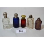 Two small silver topped scent bottles, one with blue cut glass, the other clear, and three other