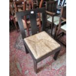 Arts & Crafts oak side chair with a plain splat back above a drop in rush seat, on plain rectangular