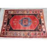 Small south west Persian rug with a medallion and floral design on a red ground with borders, 4ft