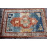 Modern Turkish carpet with a central hooked medallion design on a blue and terracotta ground with