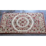 Small Numdah rug with a medallion and floral design on an ivory ground with narrow border, 4ft x 2ft