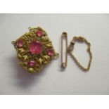 Unmarked yellow metal bar and chain, yellow metal filigree and pink paste pendant and an antique