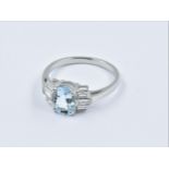 Platinum ring set with a central oval aquamarine flanked each side by 3 baguette horizontal