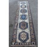 Modern Turkish runner with six medallions on a cream ground with borders, 9ft 4ins x 2ft 6ins