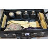 Green leather dressing case containing original silver topped dressing table bottles, brushes etc.