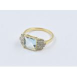 18ct yellow gold Art Deco style ring set with a central square aquamarine flanked by diamonds,