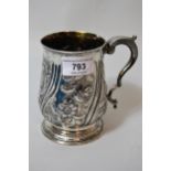 George III London silver pedestal mug with C-scroll handle and later floral embossed decoration,