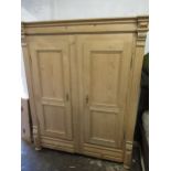 Large 19th Century Continental stripped pine wardrobe, the moulded cornice above a pair of panel