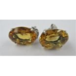 Pair of white gold stud earrings, set oval citrine and three small diamonds