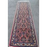 Sarouk runner with a medallion and all-over floral design on a rose ground with borders, 10ft x