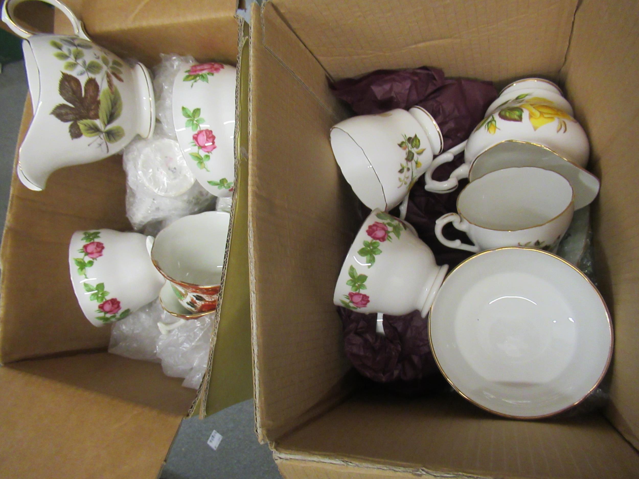 Two boxes containing a quantity of various floral decorated teacups and saucers, including a set