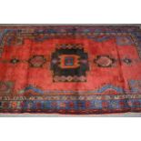 Hamadan rug with a lobed medallion design on a wine red ground with border designs, 6ft 10ins x