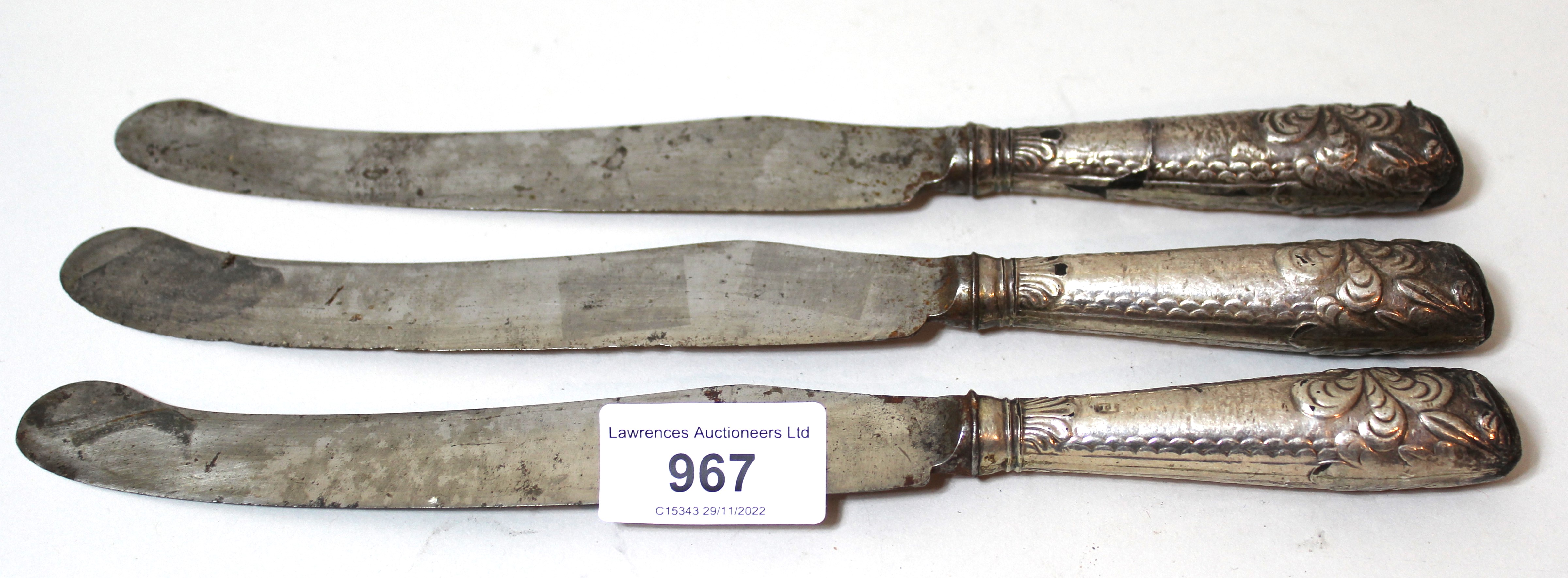 Group of three George III steel bladed knives with silver covered handles (at fault)