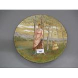 Circular Art Pottery plate, painted with figures beside a lake, indistinct label verso, 11.5ins