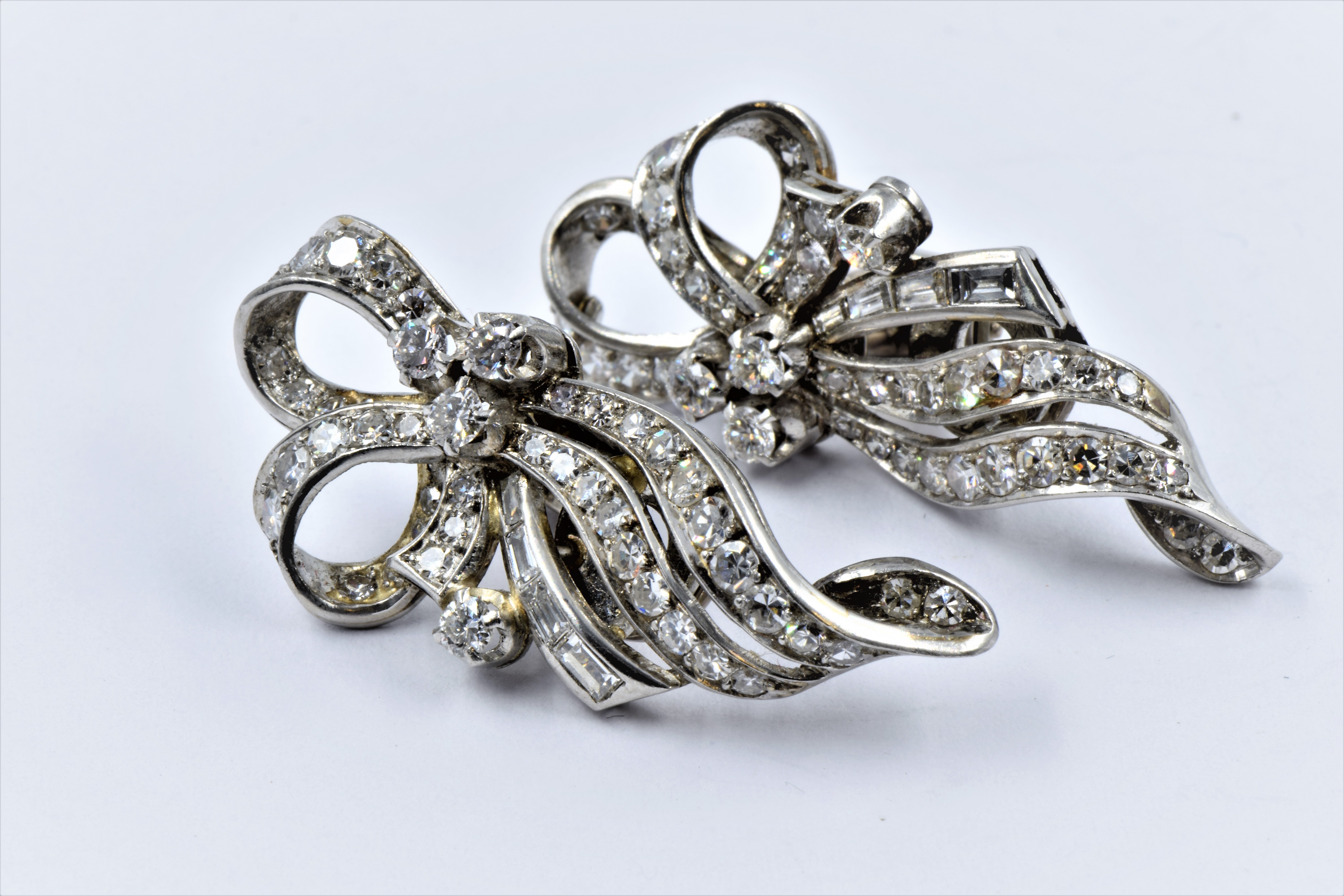 Pair of mid century high carat white metal and diamond set ear clips of Art Deco design, set with