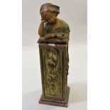 Painted plaster bust of a child reading a book, mounted on a giltwood and marble plinth (damages and