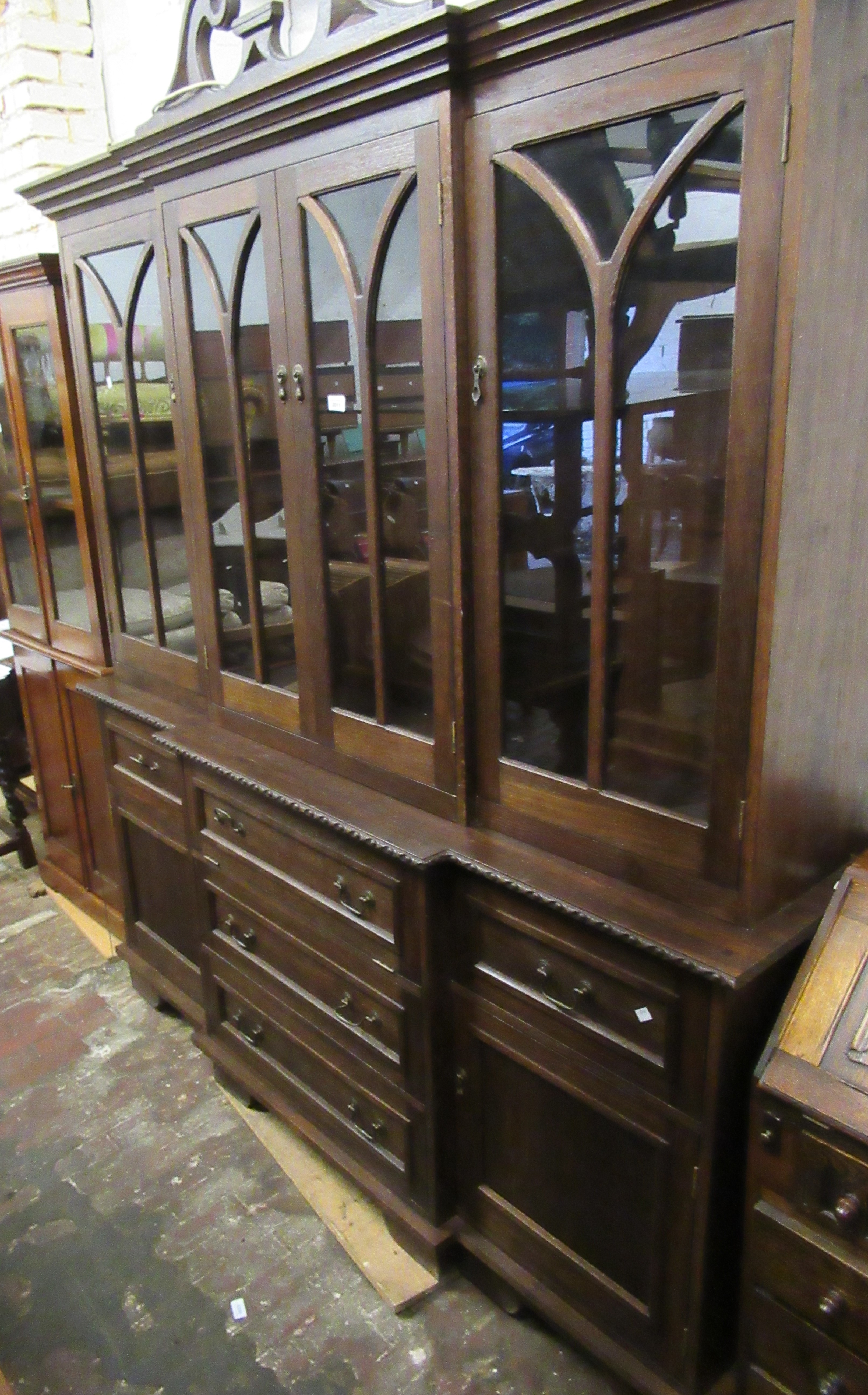 20th Century oak breakfront four door bookcase, the glazed top above an arrangement of various