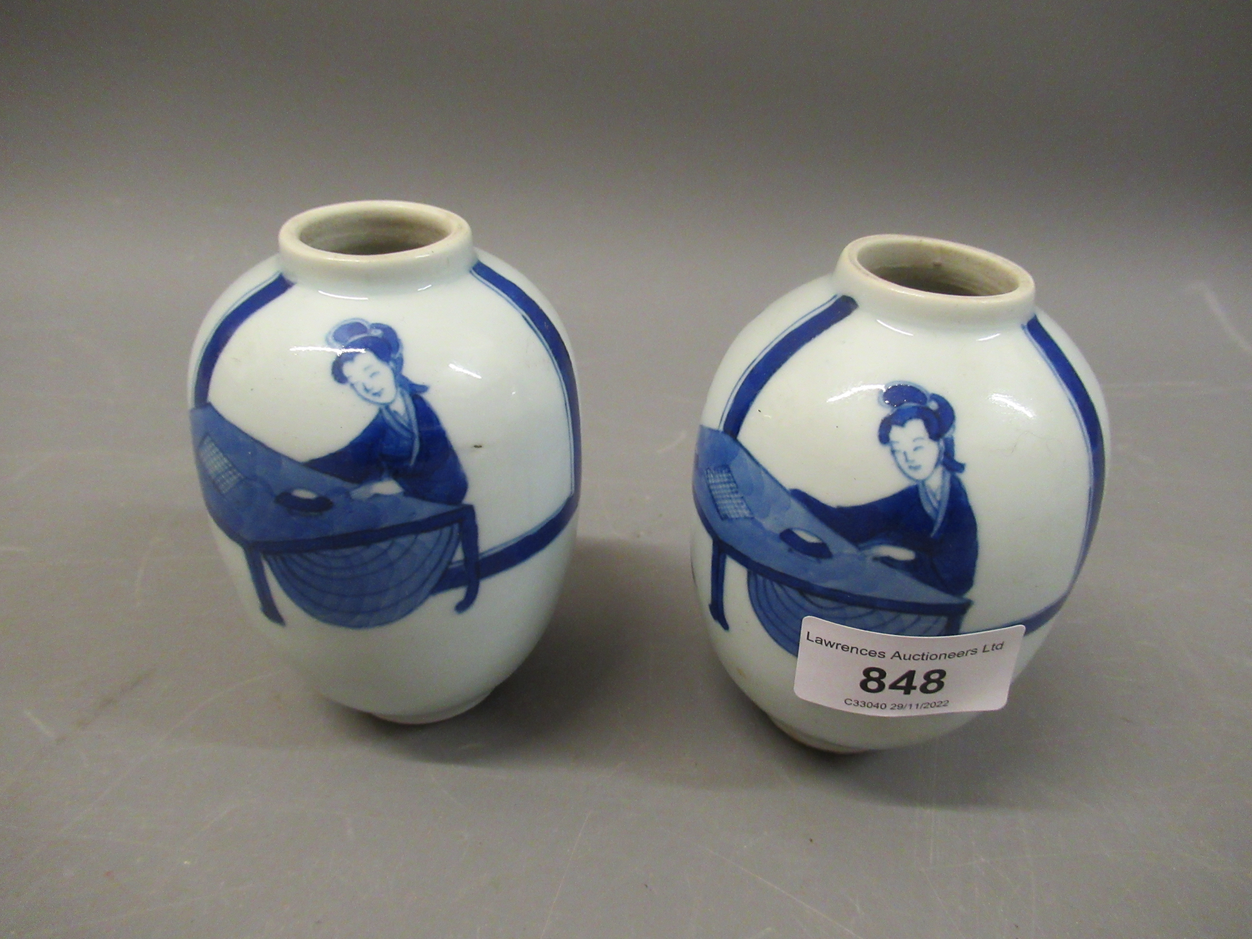 Pair of small Chinese baluster form vases, blue and white decorated with figures seated at a