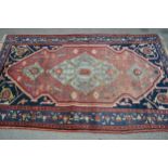 Hamadan rug with a lobed medallion and stylised floral design on a rose ground with deep blue corner