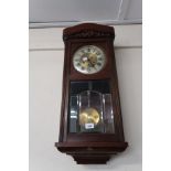 20th Century walnut cased Vienna style wall clock, the circular silvered dial with Roman numerals,