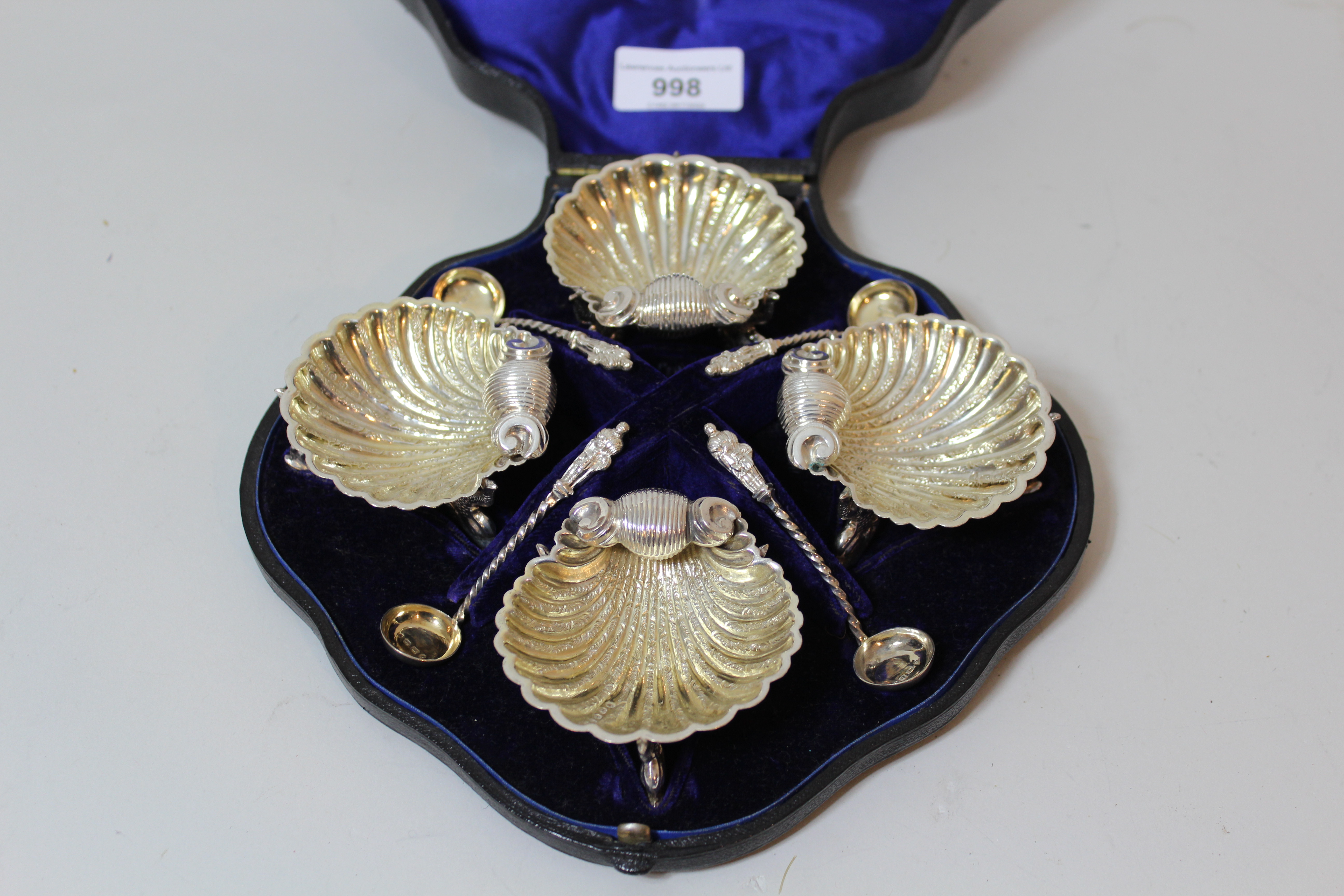 Cased set of four Victorian silver shell form salts with apostle handled spoons 5.5ozs