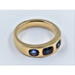 Yellow metal three stone sapphire ring, size 'J.5'