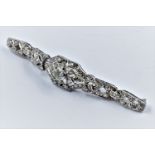 High carat white metal and diamond set bar brooch of Art Deco design, set with a variety of