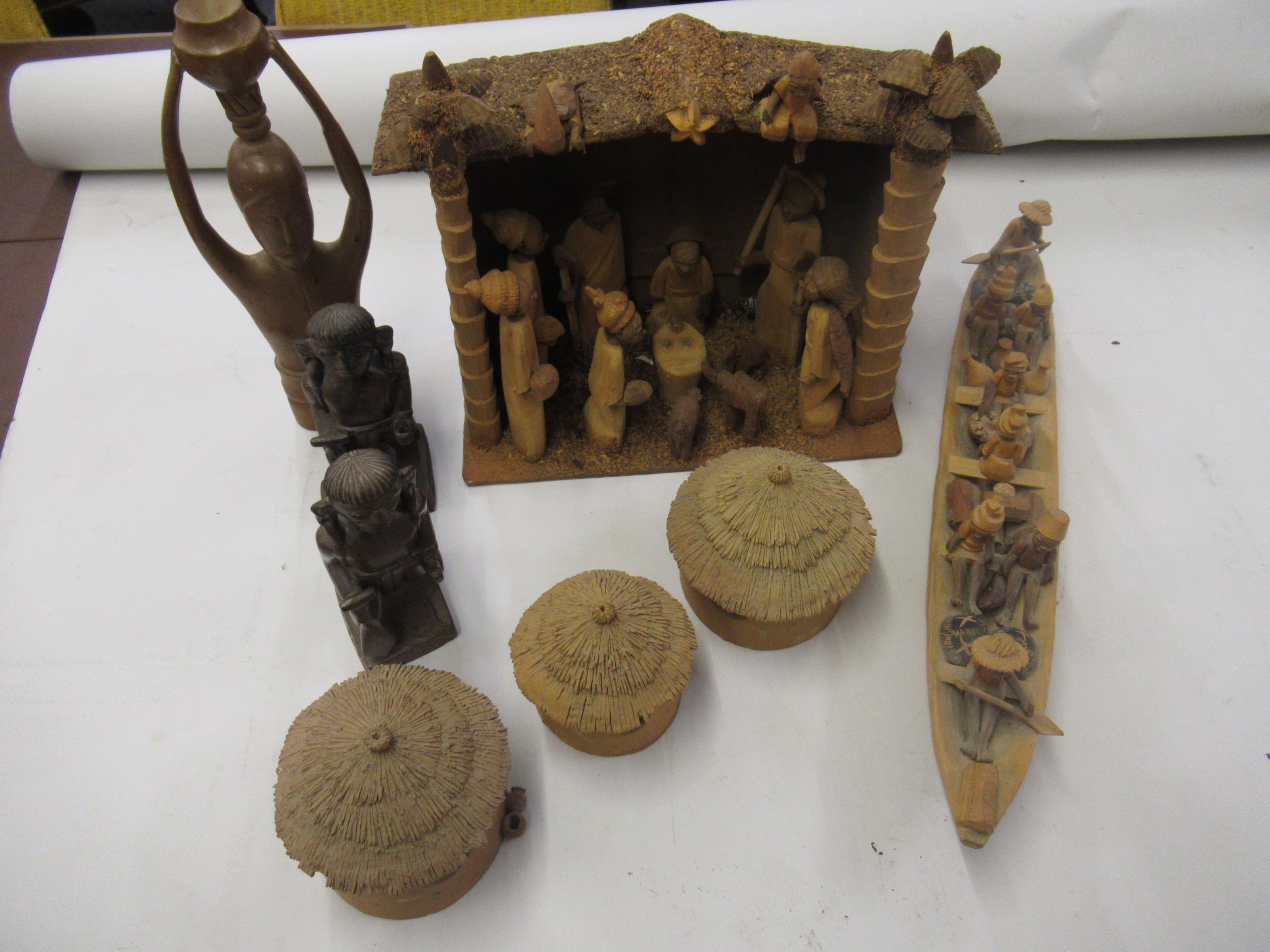 Nigerian carved wooden nativity group, similar model of figures in a boat, gaming board and three