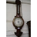 Late Victorian carved oak aneroid barometer/thermometer, the silvered dial inscribed Negretti and