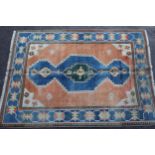Modern Turkish carpet with a central lobed medallion design on a terracotta ground with blue