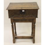 17th Century oak bible box, the hinged sloping plank top above a carved panel front, raised on a