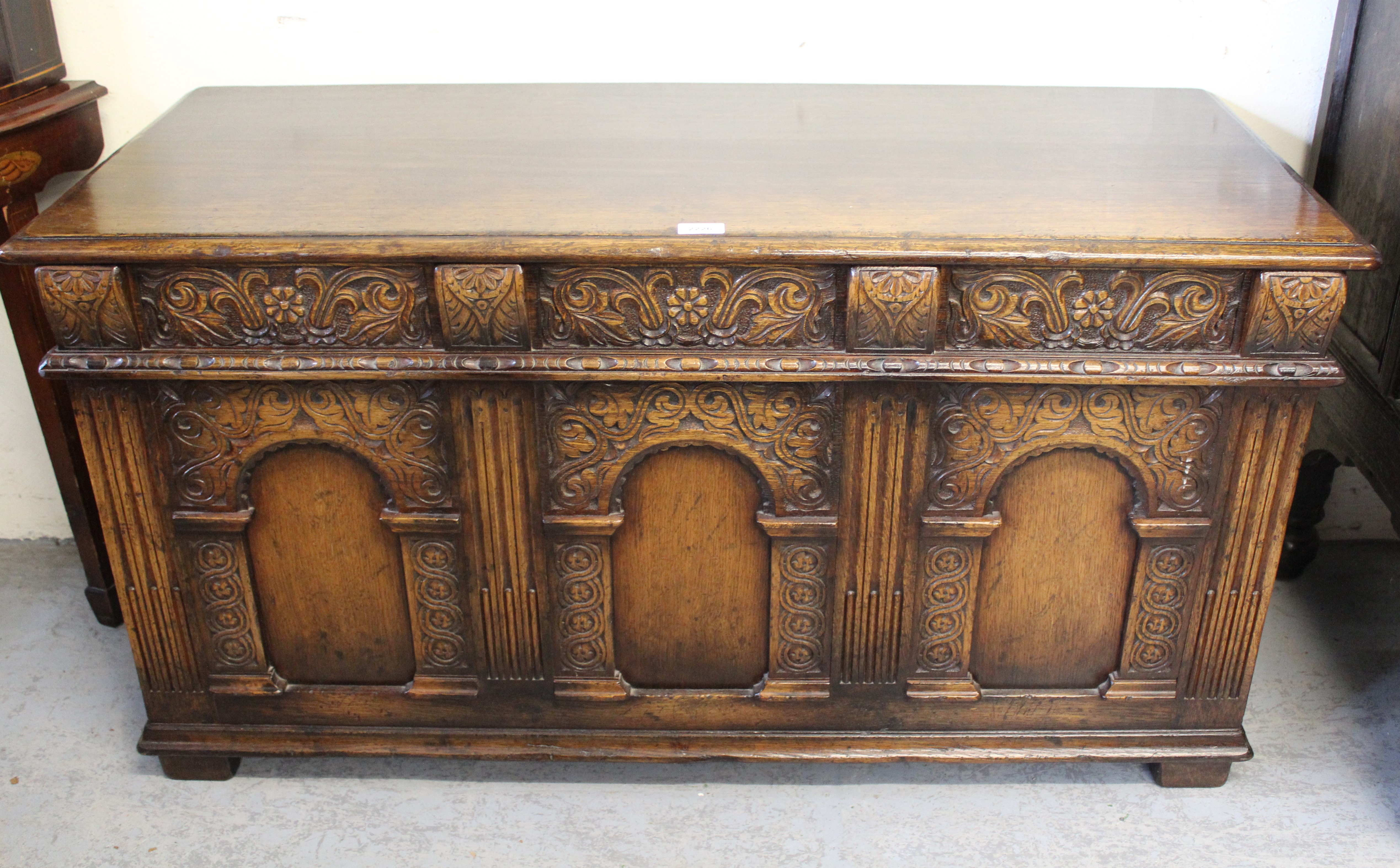 Good quality reproduction carved oak coffer, the hinged moulded lid above a carved frieze and