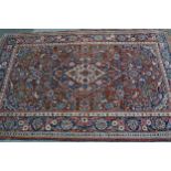 Kashan rug with a lobed medallion and all-over stylised floral design on a red ground with