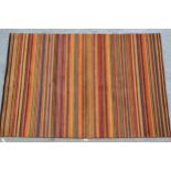 Modern Tibetan rug woven with a polychrome stripe design in shades of red, orange, green, beige