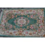 Small Chinese carpet with an embossed floral design on a green ground with borders, 9ft x 6ins
