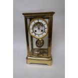 Late 19th Century gilt brass four glass library clock, the enamel dial with Roman numerals and two