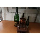 Three various empty champagne bottles, Bollinger, Krug etc, together with an oak and copper