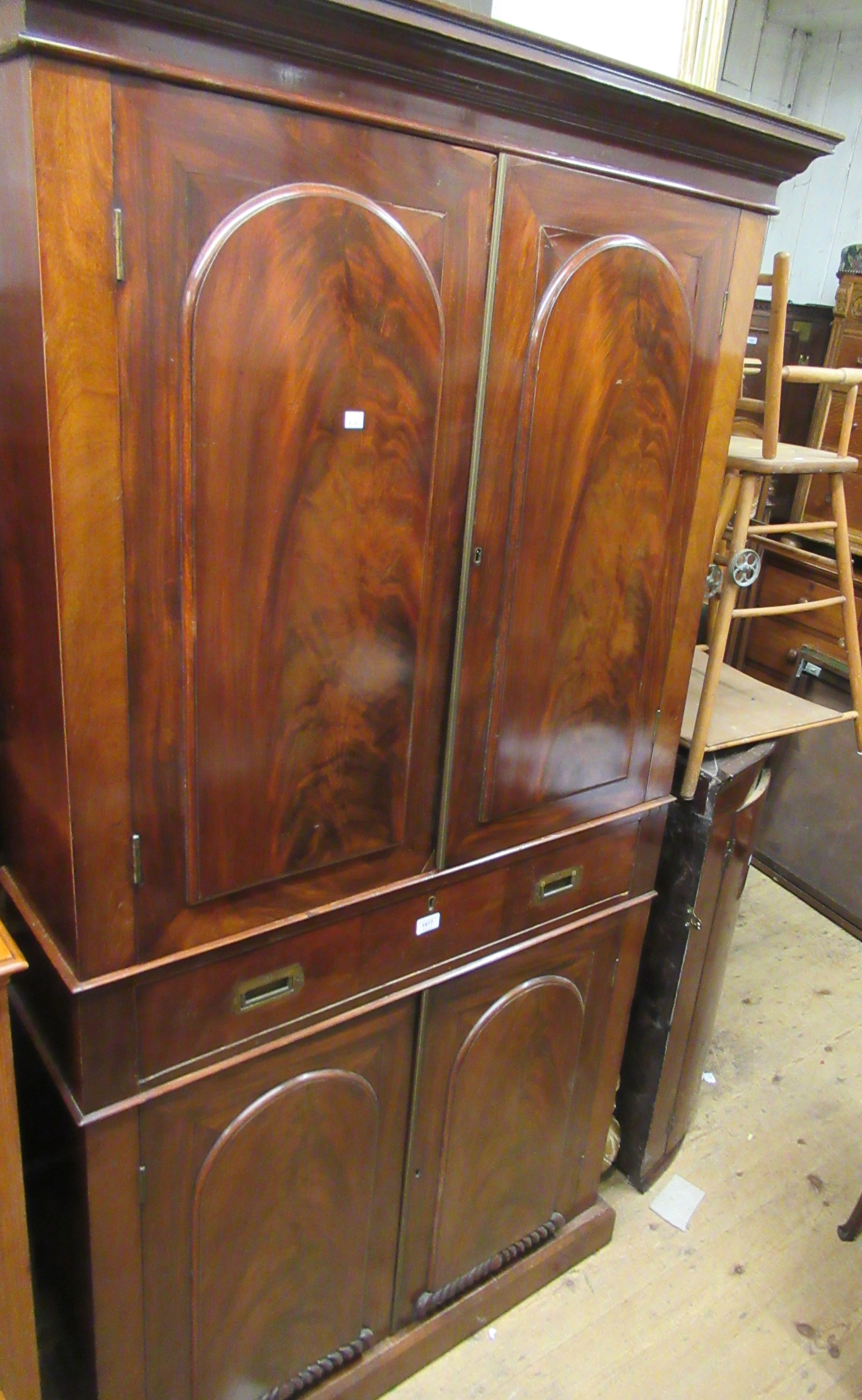 19th Century figured mahogany bookcase, the moulded cornice above a pair of arched figured panel