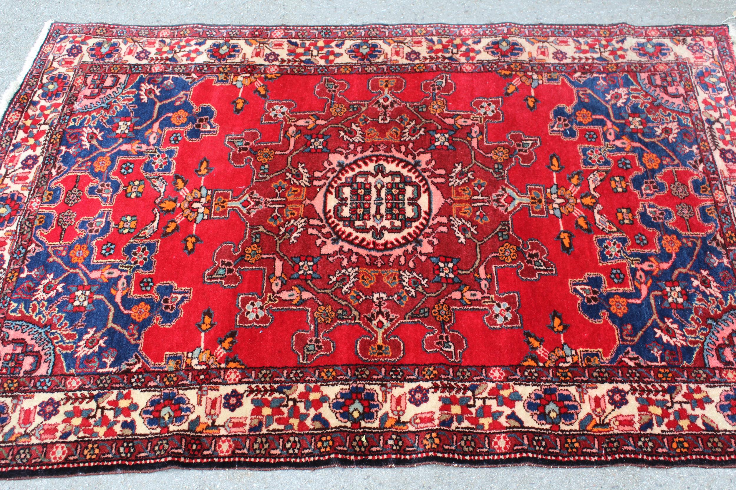 Tabriz rug with a medallion design on a red ground, with blue corner designs and borders, 6ft x