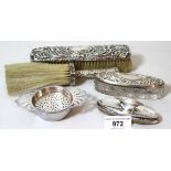 Two silver mounted brushes, dressing table box, nail buffer and a silver tea strainer on stand