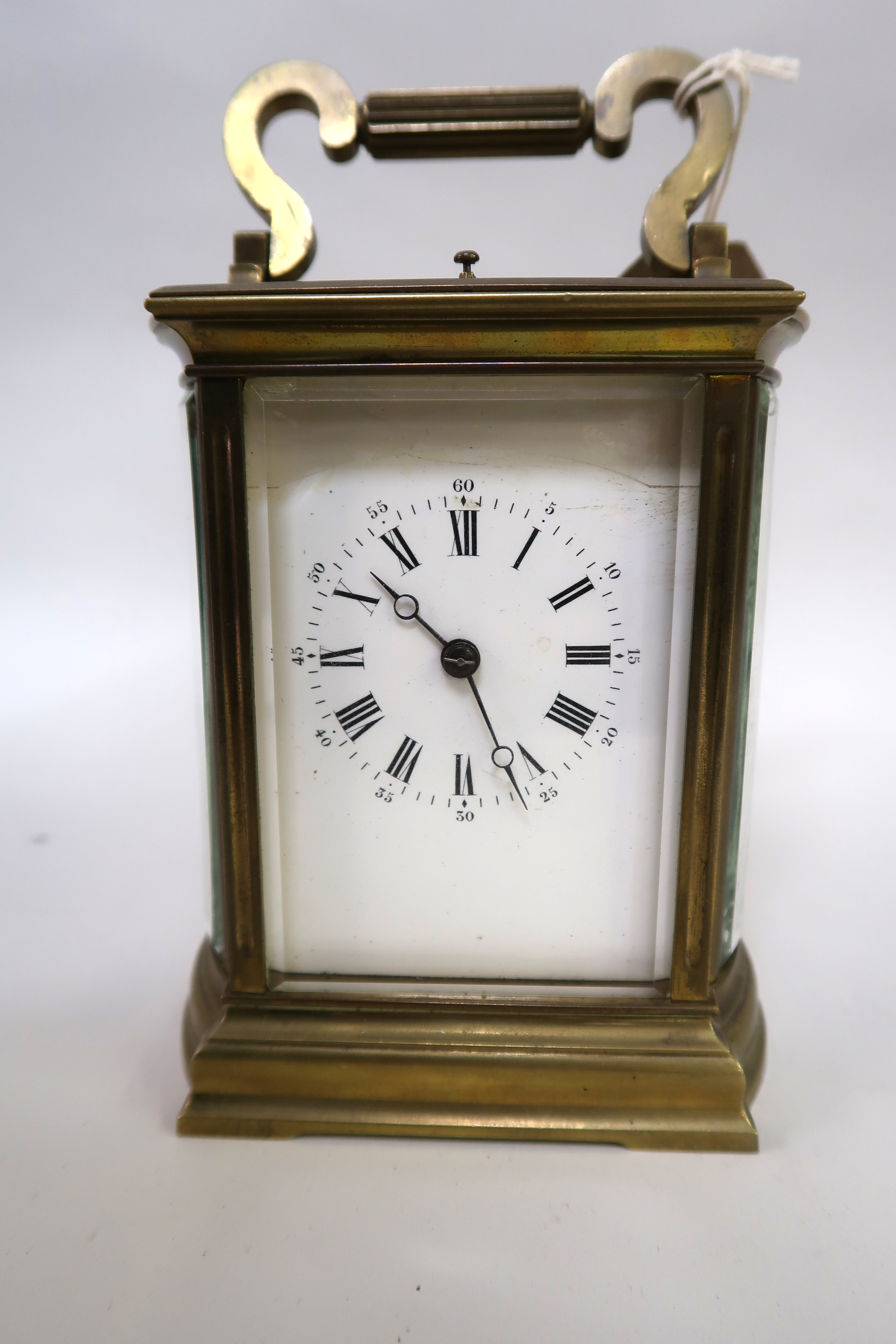 Late 19th / early 20th Century carriage clock, the brass case with bow end panels, enamel dial