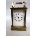 Late 19th / early 20th Century carriage clock, the brass case with bow end panels, enamel dial