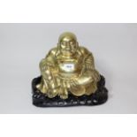 Late 19th / early 20th Century Chinese gilt bronze figure of seated buddha, on a carved hardwood