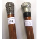 Lacquer walking cane with an oriental white metal pommel, another similar walking cane and a World